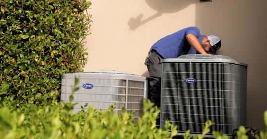 technical looking at an HVAC system
