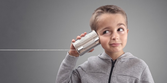 kid holding a tin can telephone