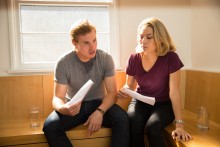 Young couple in home that is too hot reading high utility bills