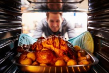 man pulling turkey from oven