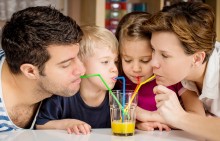 family sharing a glass of juice