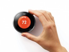 Nest Thermostat with hand adjusting the controls