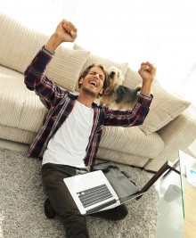 man at home with computer with angry arms in the air