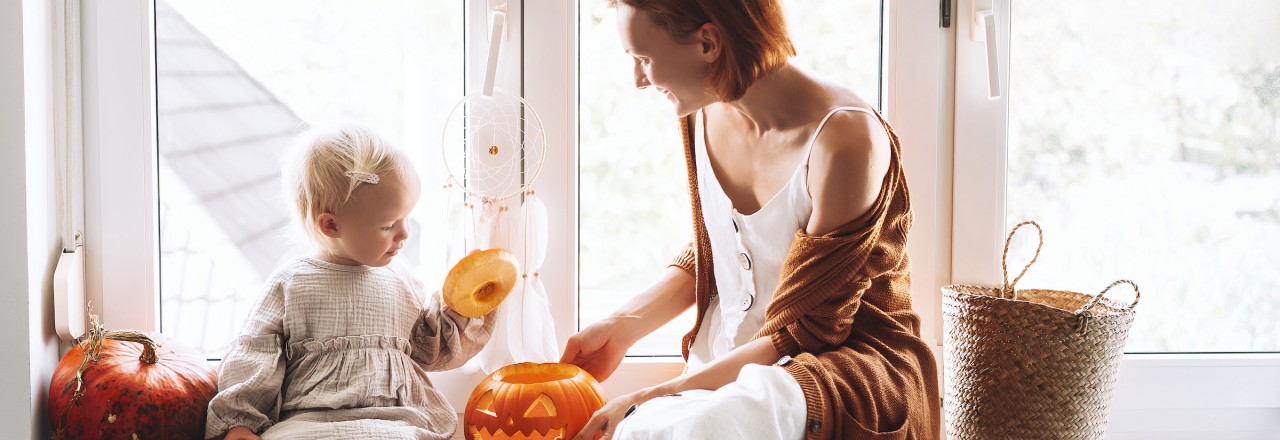 mother and daughter sitting buy window with a pumpkin