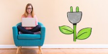 woman in chair next to green energy symbol