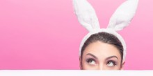 woman peeking over table with bunny ears on
