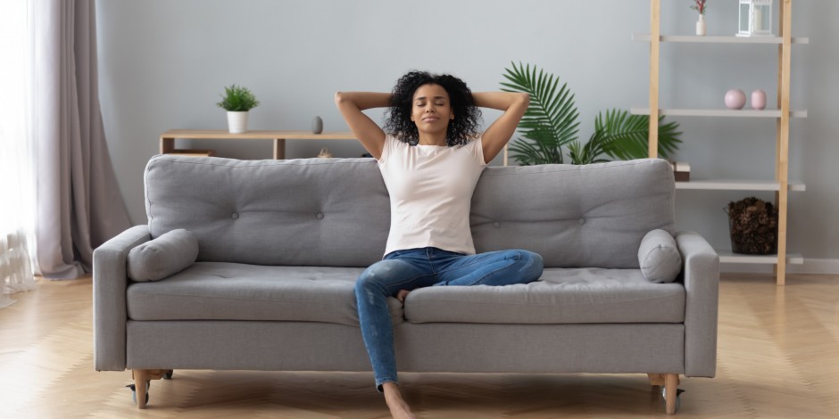 woman relaxing on couch in a clean house with plants