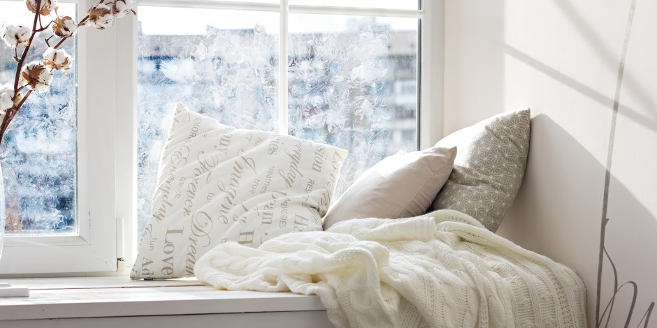 cushions and a knitted plaid on the cold windowsill