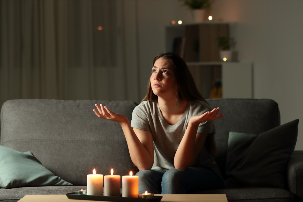woman at home surrounded by lit candles because the power is out