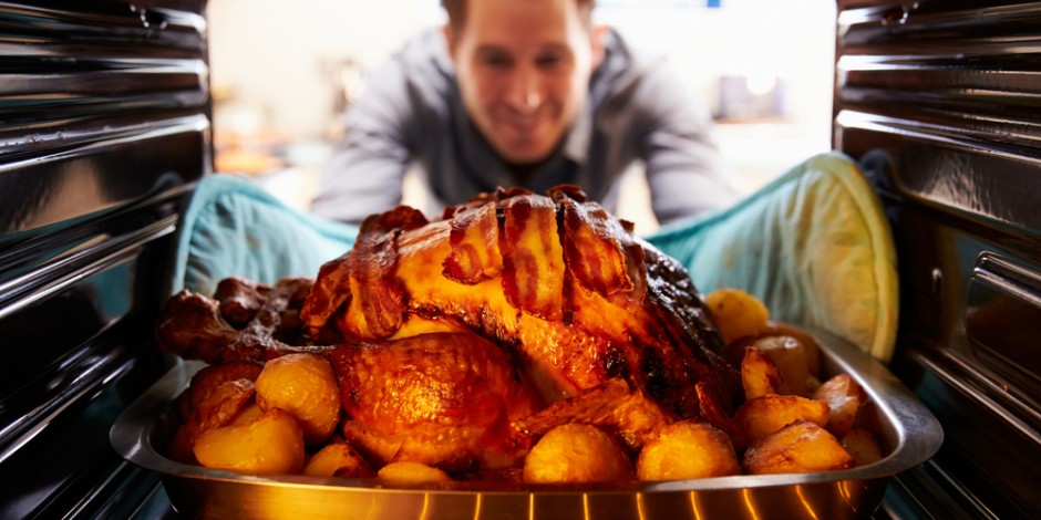 man pulling turkey from oven