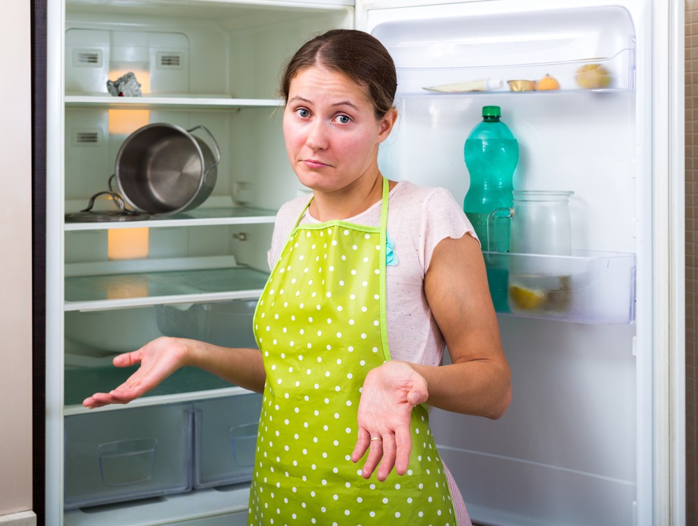 woman confused by fridge at home