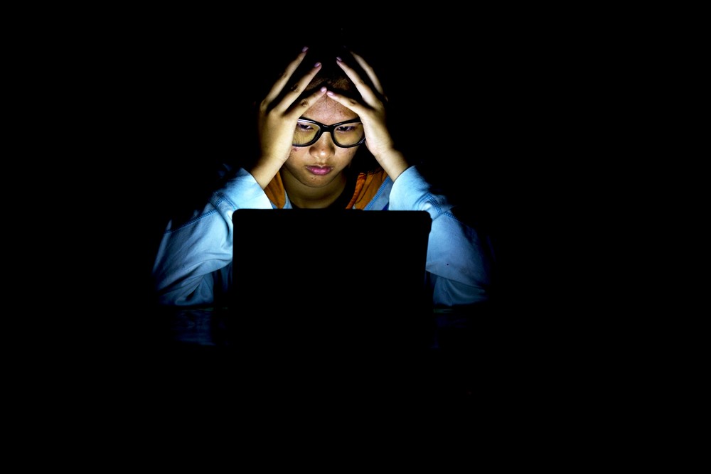 girl in the dark with laptop during power outage